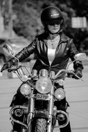 cool girl in leather jacket rides motorbike