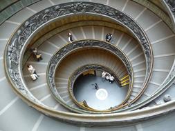 People, on the beautiful spiral staircase with the ornamental railings, in the Vatican Museum