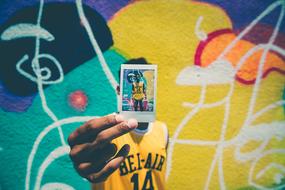 Polaroid Photo in male hand, graffiti