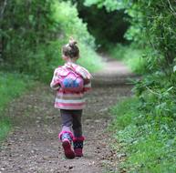 child Girl Walking away on Path through greenery