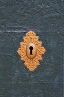 Beautiful, yellow copper lock keyhole in the blue surface