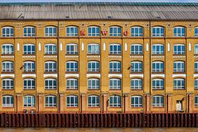 building with a yellow facade on the banks of the Spree river