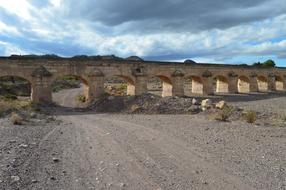 Beautiful stone aqueduct in Spain, under the blue sky with clouds