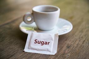 Sugar sachet next to the white cup