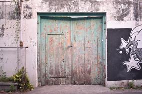 Old, colorful gate in the building with graffiti