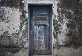 old dilapidated door on a weathered facade