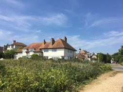 Beautiful and colorful houses, among the plants in Keyhaven, Hampshire, England, under the blue sky with white clouds