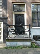 Black bike near the door of the building in Amsterdam, Netherlands