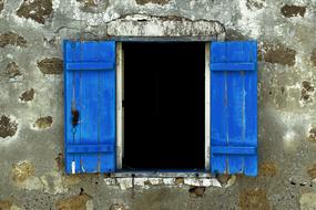 window with blue wooden shutters on the old facade