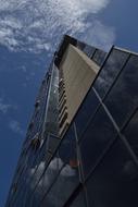 Low angle shot of the shiny office tower with the windows, in Camoruco, Valencia, Venezuela, under the blue sky with clouds