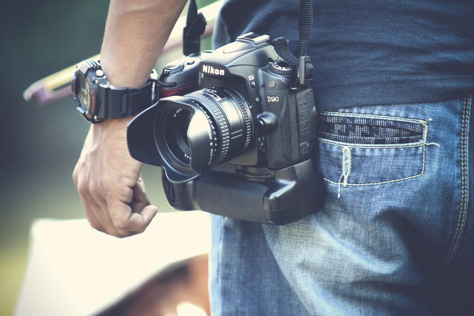 Black camera hanging on a man's shoulder