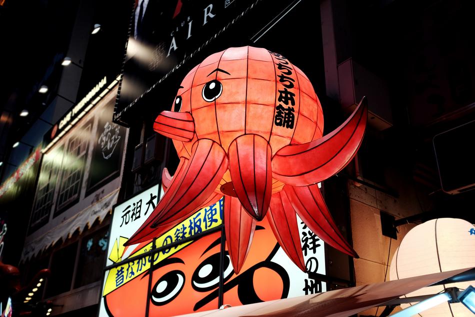 octopus shape balloon in front of wall in city at Dark Night