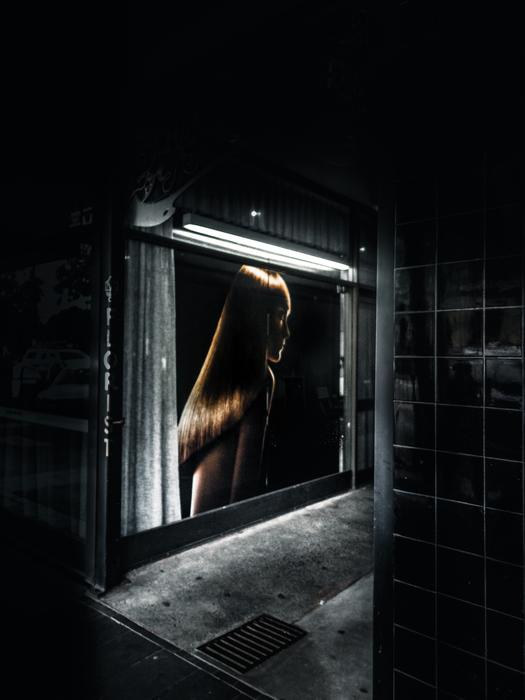 Building with the image of the girl, in lights, among the darkness