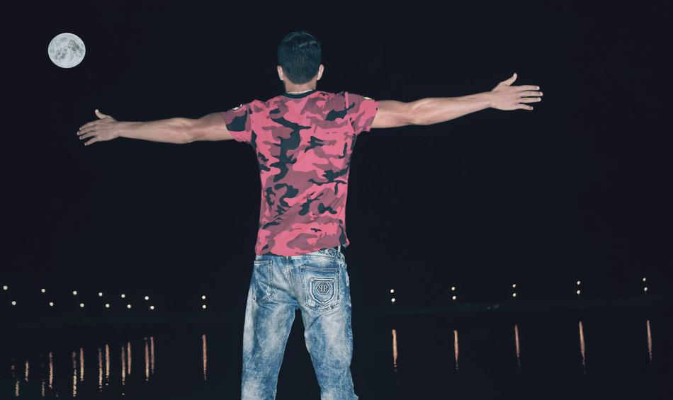 Man in front of water at full moon night