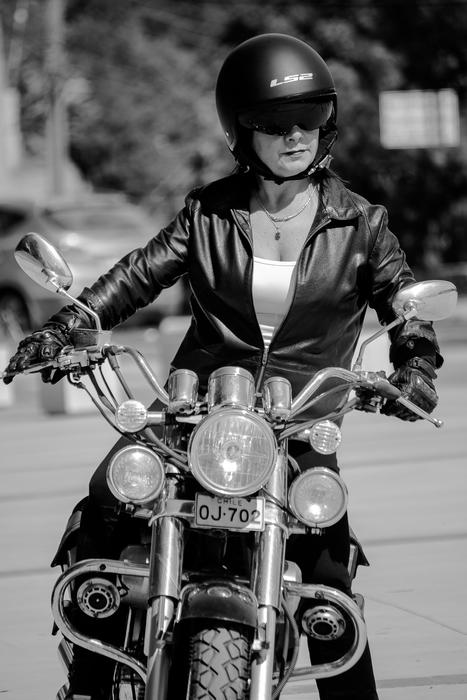 cool girl in leather jacket rides motorbike
