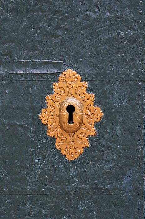 Beautiful, yellow copper lock keyhole in the blue surface