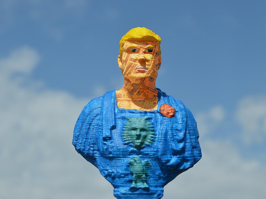 Colorful bust of Donald Trump, under the blue sky with white clouds