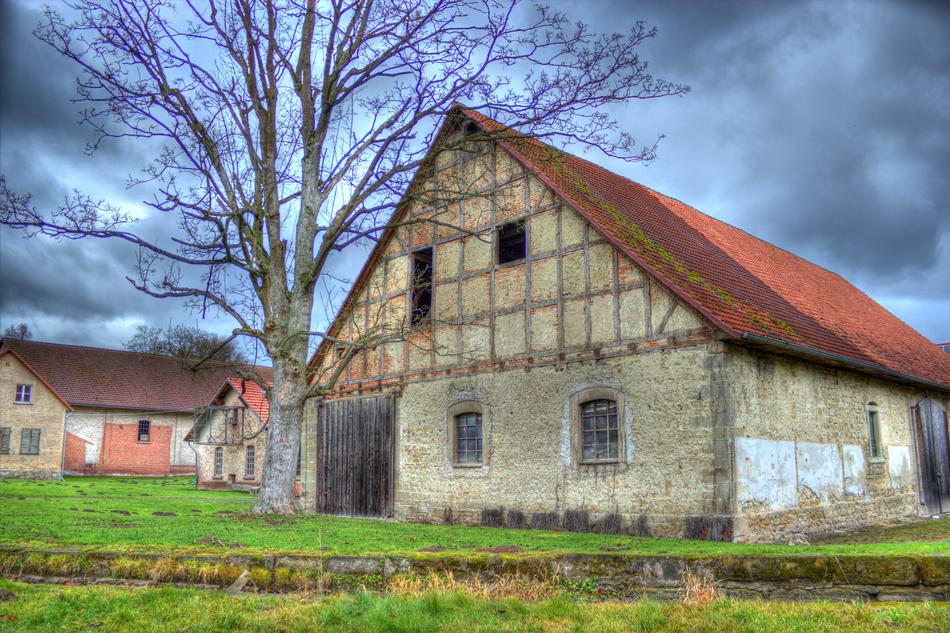 Landscape with the beautiful and colorful barns, among the plants, under the clouds