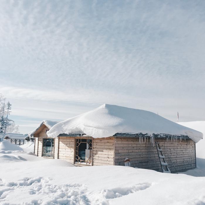 Beautiful landscape with the wooden house, in white snow, in winter, under the cloudy sky