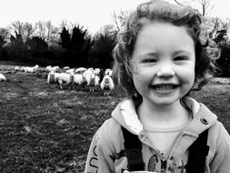 Sheep and Girl in the pasture in black and white background