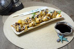 sushi on a plate and soy sauce on a table in a restaurant