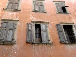 Old, brown building with the windows, with the wooden shutters