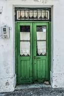 Beautiful, old, green wooden door in the white building, in Skopelos, Greece