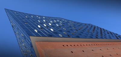 Low angle shot of the beautiful, shiny Elbe Philharmonic Hall in Hamburg, Germany, under the blue, gradient sky