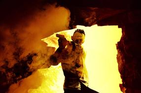 Man with gun in cave opening