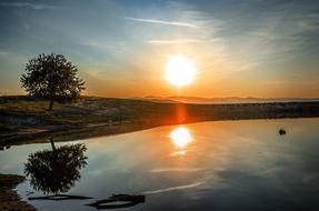 the big sun is shining over the lake