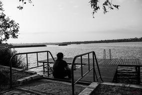 Black And White photo of human on pier