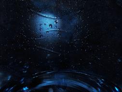 Close-up of the blue and black surface with waters, among the darkness