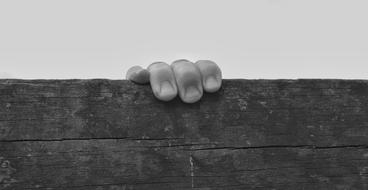 monochrome photo of Hand of Child on Board