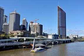 Beautiful cityscape of Brisbane, Australia, with the colorful buildings, plants, and boat on the water