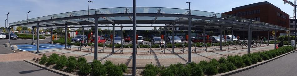 Panoramic view with the cars on the parking, under the glass and steel cover