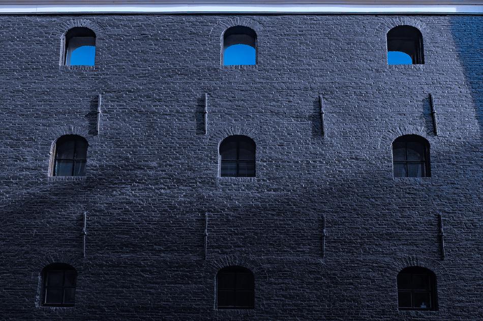 Facade of the building with windows, in moonlight and shadow