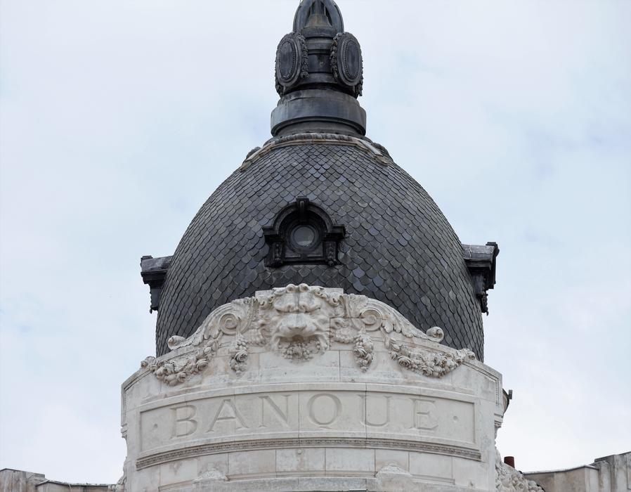 Beautiful, patterned dome with the 'Banque' sign, at cloudy sky on background
