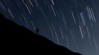 man hiking uphill at night starry sky, digital art