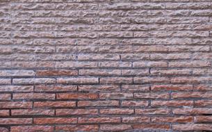 Close-up of the colorful brick wall with bricks of different shades