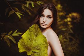 Girl and big leaf on a blurred background
