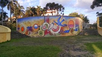 Colorful graffiti on the wall, among the palm trees, in Curitiba, Parana, Brazil