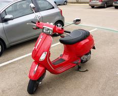 red vespa scooter in the parking lot