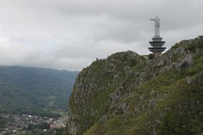 Beautiful landscape with the statue on the green mountain in Indonesia, under the clouds