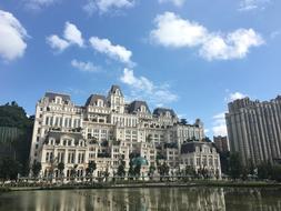Beautiful hotel on the shore of the water, in China, under the blue sky with white clouds