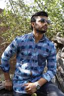 stylish young man posing in nature