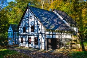 Beautiful, old, white Truss house, near the colorful trees, in autumn