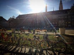 People at the beautiful and colorful park, with the bikes, in sunlight, near the buildings, on Dolomites in Italy