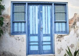 closed blue shuttered door in an old house