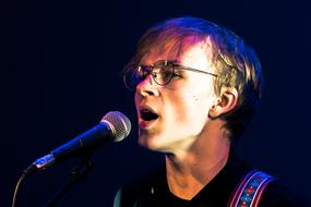 portrait of young boy in glasses singing