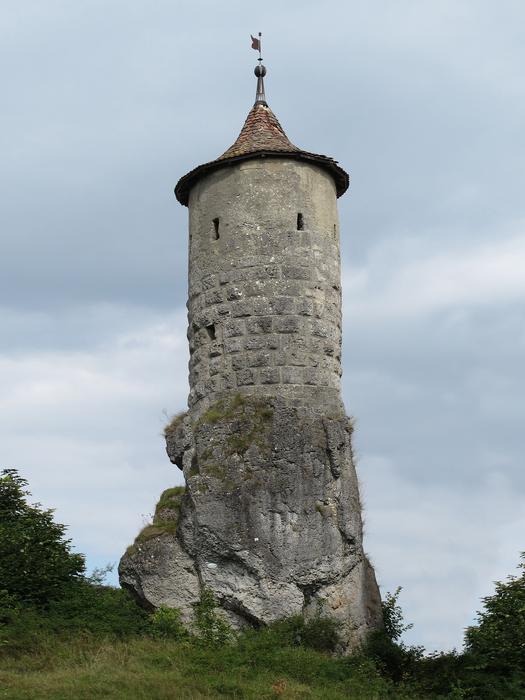 Old, defensive tower, among the green plants, in Waischenfeld, Germany, under the clouds